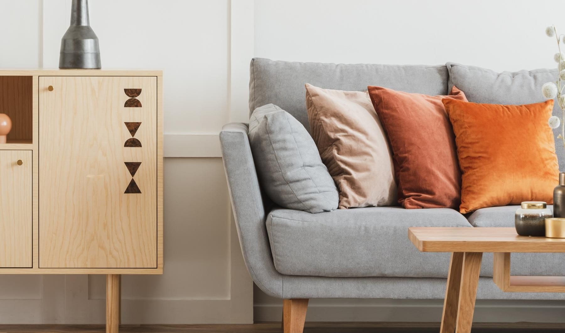 a couch with pillows and a vase