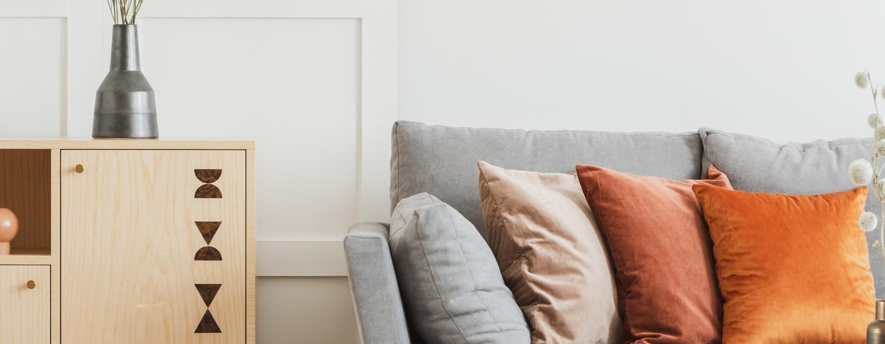 a couch with pillows and a vase