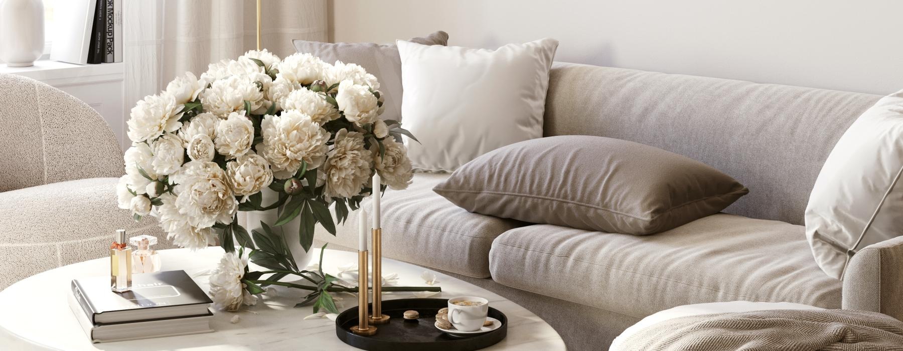 a white couch with a table and a white table with flowers on it