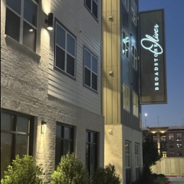 exterior of building with green turf and some seating