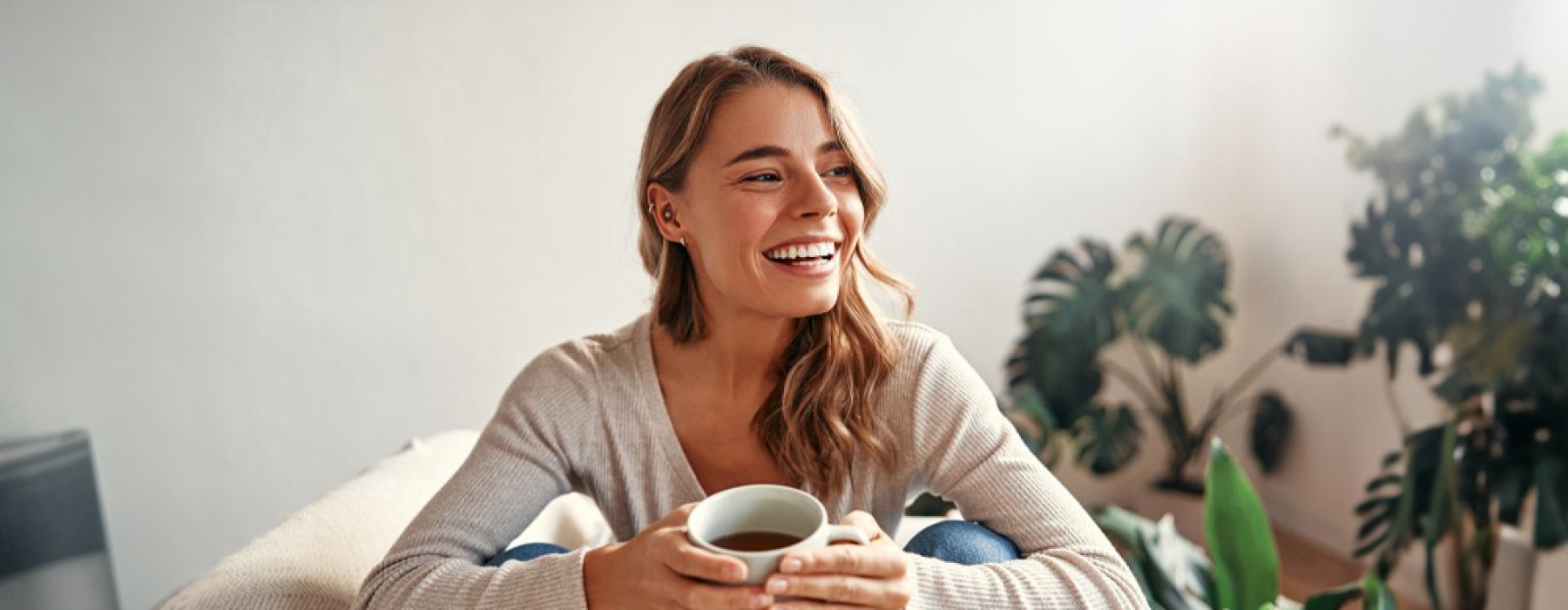 a smiling woman with a mug of coffee